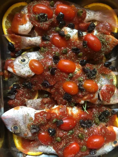 Fisch aus dem Ofen mit Tomaten Ganze Fische mit Kirschtomaten und Kräutern im Ofen gegart.