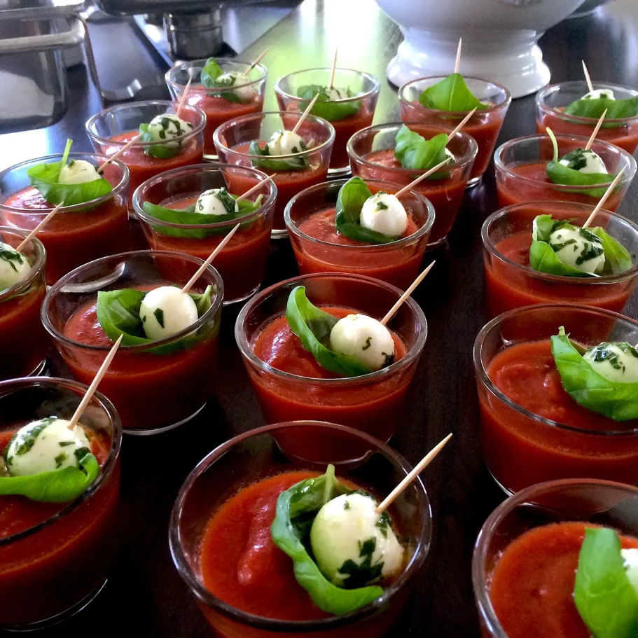 Tomatensuppe im Glas Tomatensuppe in kleinen Gläsern mit Mozzarella und Basilikum als Vorspeise