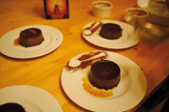 Schokoladendessert auf Teller Schokoladenkekse auf Tellern, serviert mit einer fruchtigen Sauce und Puderzucker.